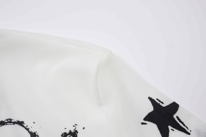 Close-up of white sleeve hem with black lightning and star print