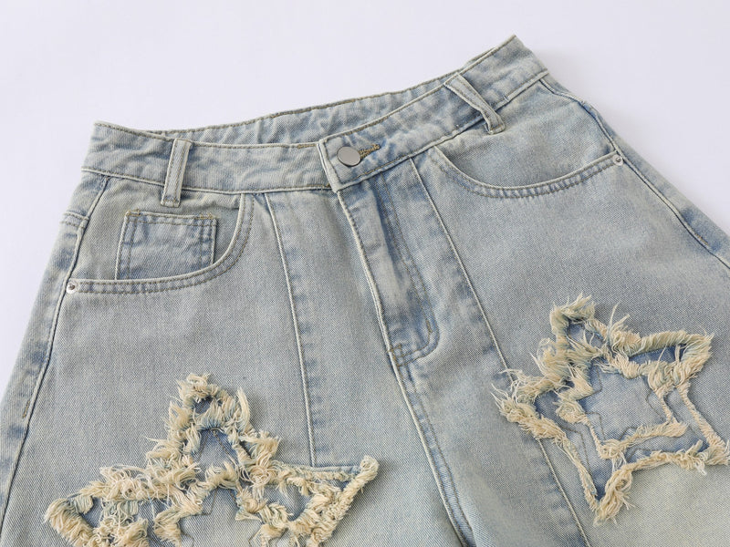 Close-up of the front waistband and pocket area on light wash distressed denim jeans