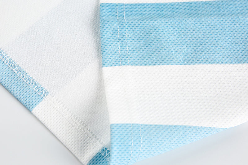 Close-up of side seam and sleeve panel stitching on light blue color-block tee