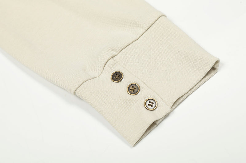 Cream cuff close-up with three buttons and ribbed sleeve opening