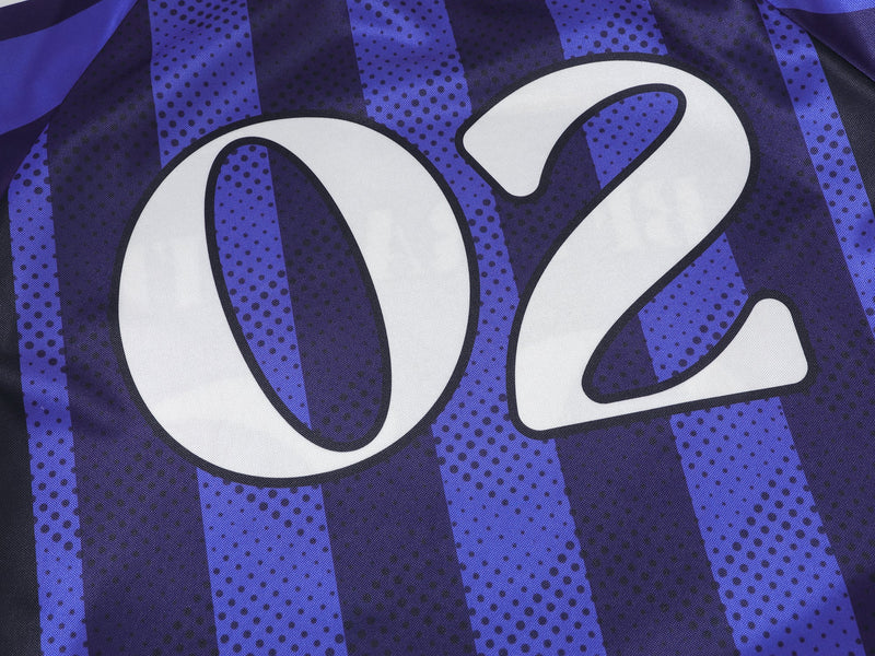 Close-up of blue jersey front showing large 02 print over vertical striped fabric