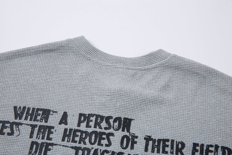 Light gray textured half-zip graphic T-shirt with bold black streetwear slogan print on the chest
