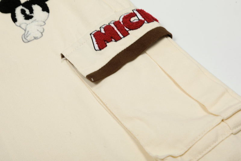 Close-up of cartoon character patch and red pocket lettering on cream cargo pants