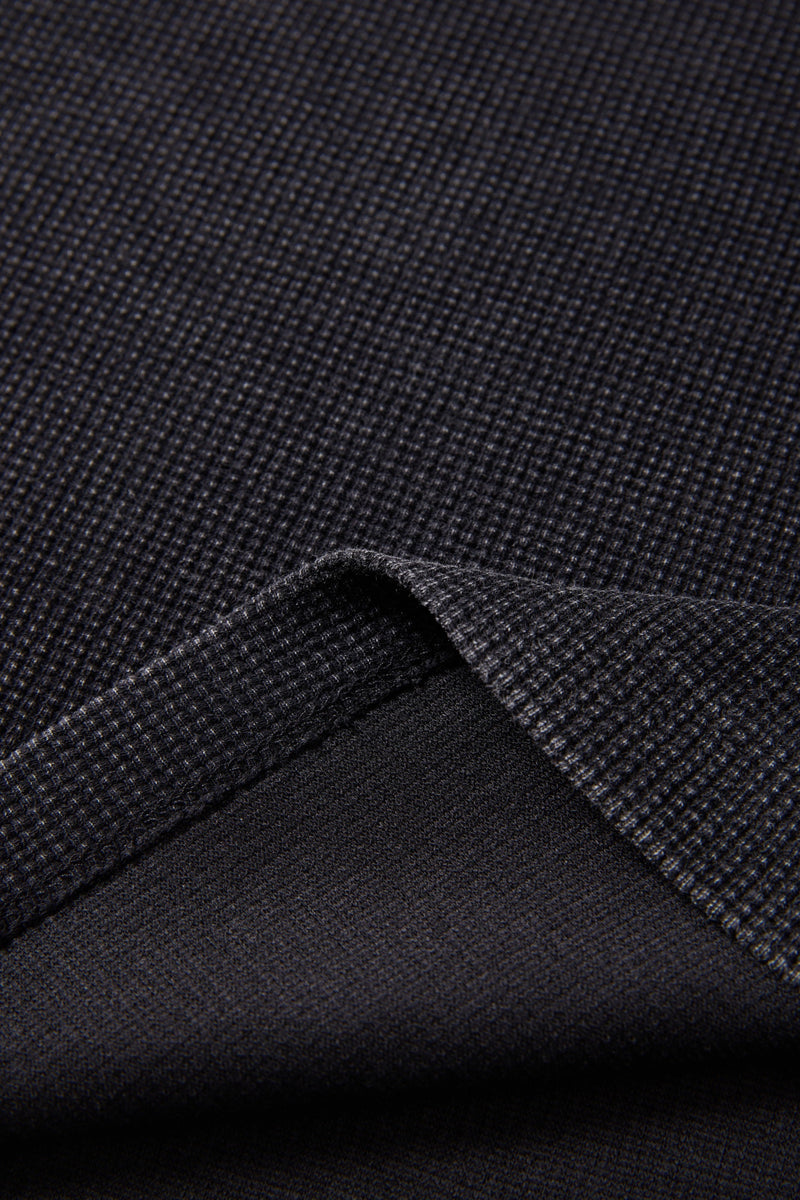 Close-up of black textured graphic T-shirt fabric with folded sleeve and ribbed knit detail