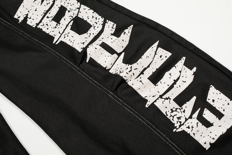 Close-up of the right leg graffiti print on black denim pants with contrast stitching
