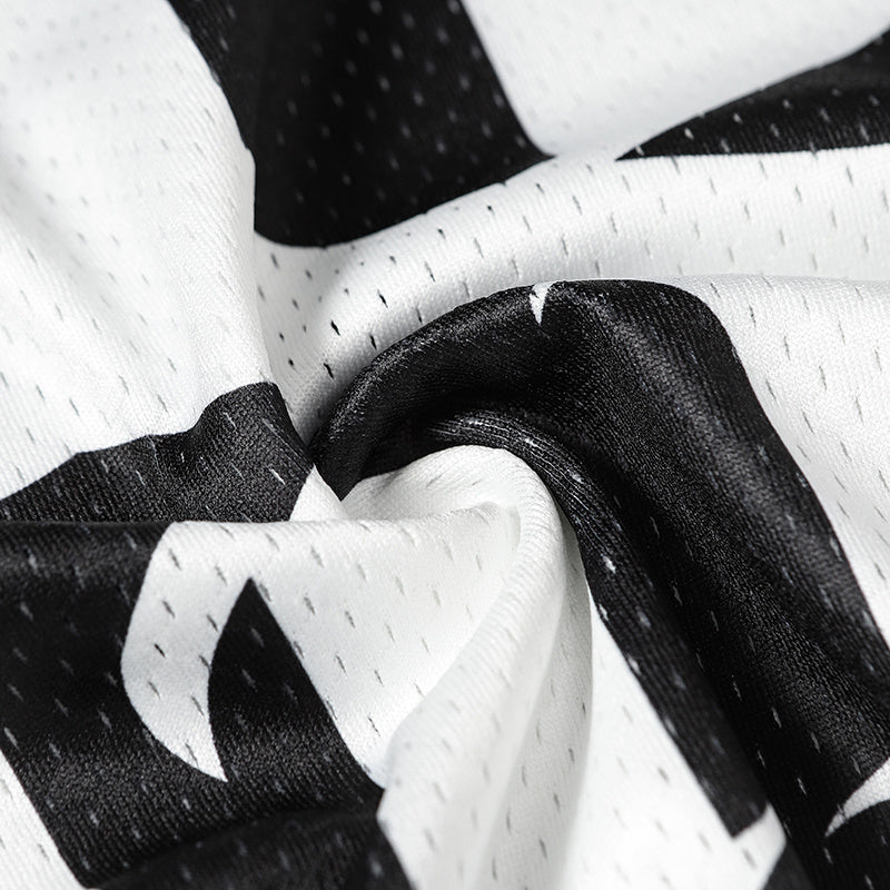 Close-up of black and white mesh jersey fabric with bold gothic varsity number print and textured streetwear detail