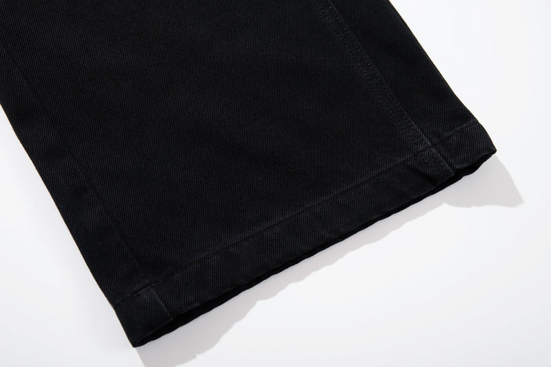 Close-up of black jean hem showing wide-leg cut and stitched edge