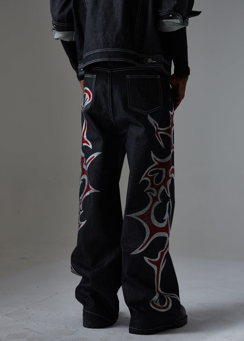 Back view of black wide-leg denim pants with flame rhinestone designs along both legs
