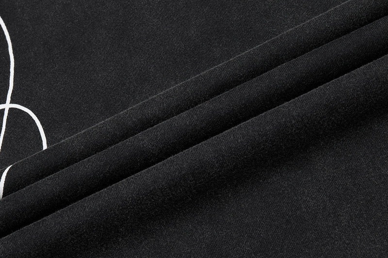 Close-up of a black washed streetwear T-shirt with white curved crest graphic and textured vintage fabric