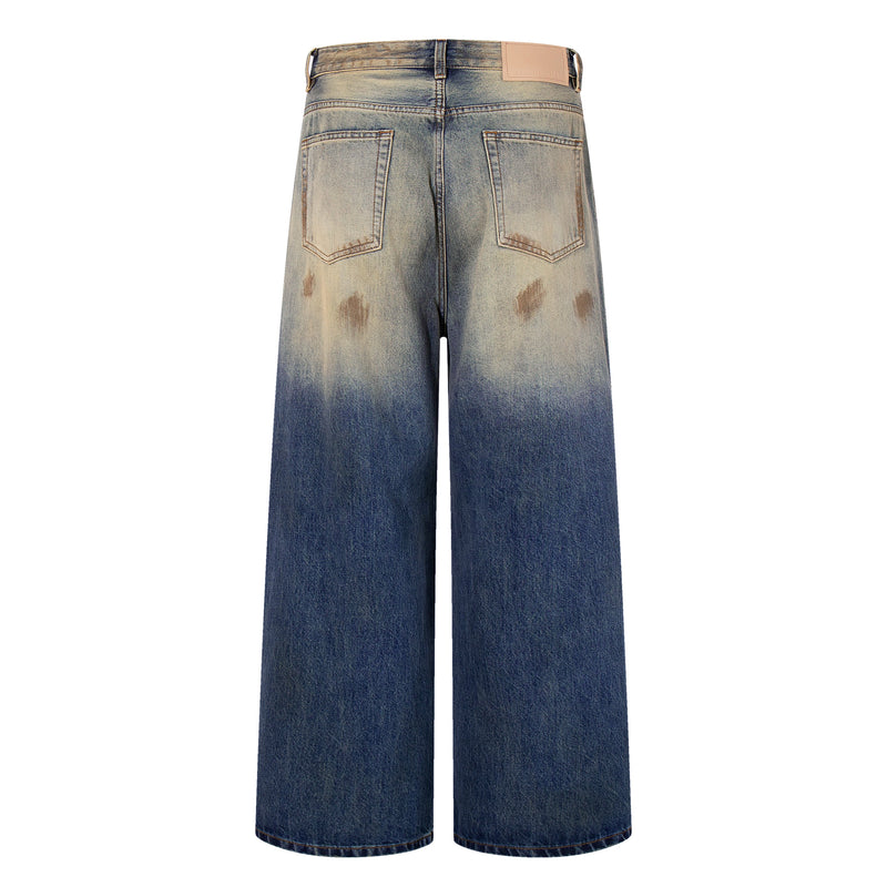 Back view of wide-leg jeans with faded gradient wash, patch pockets, and leather back label
