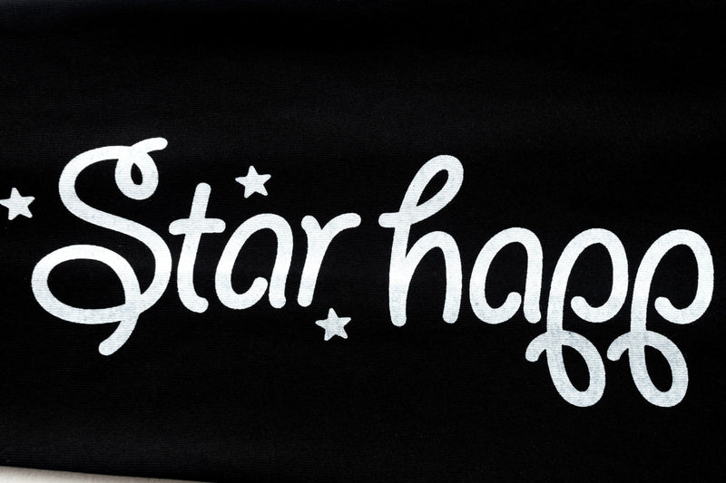 Black sleeve close-up with white stylized 'Star happ' lettering