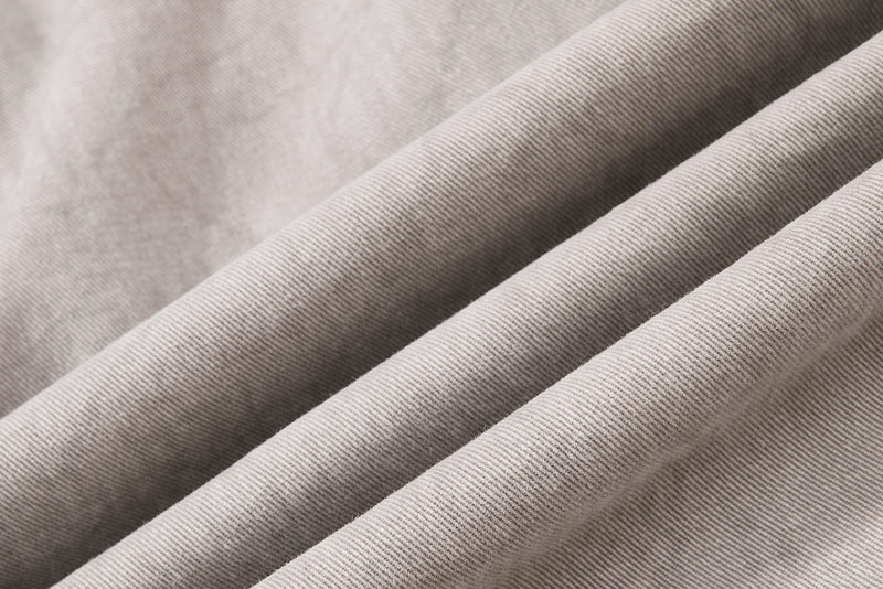 Light beige denim fabric close-up with soft washed texture and diagonal folds