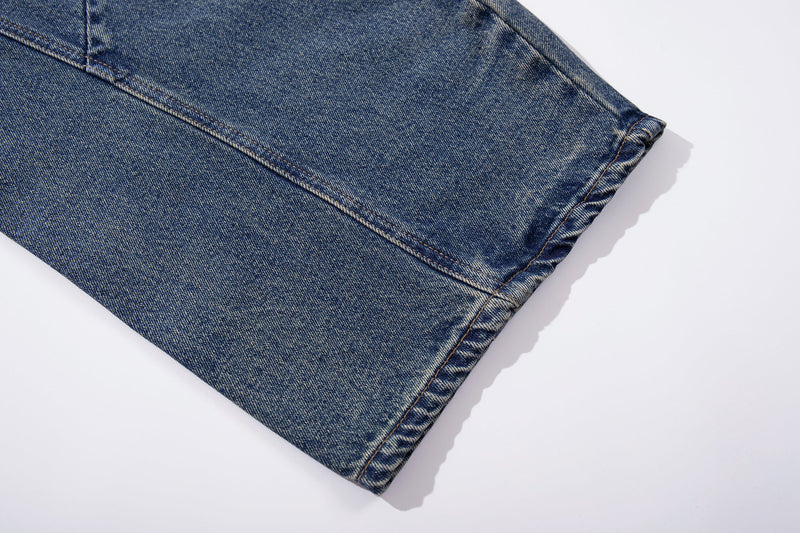 Close-up of hemmed cuff on blue denim wide-leg jeans