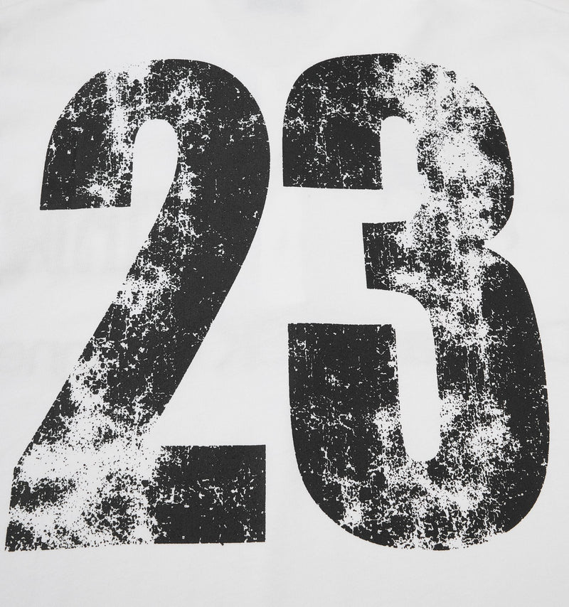 Close-up of a white streetwear polo tee with oversized distressed black 23 graphic print on the chest