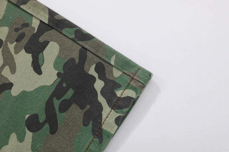 Close-up of the pant hem showing green camouflage fabric and stitched edge