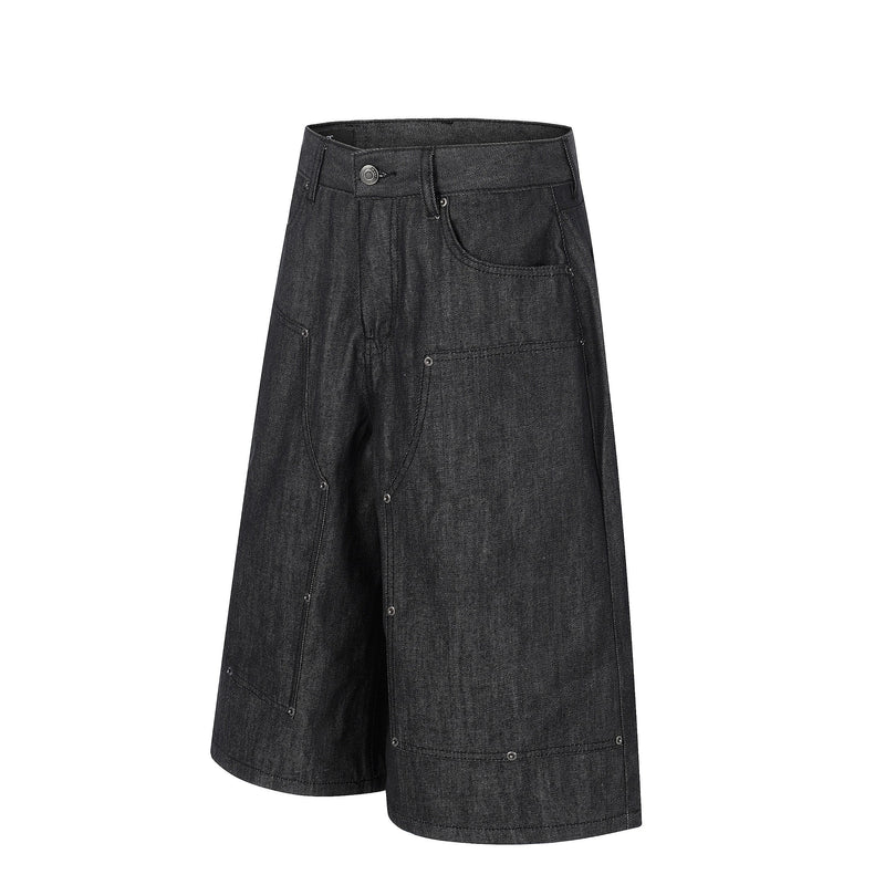 Angled front view of black wide-leg denim shorts with large front pockets and rivets