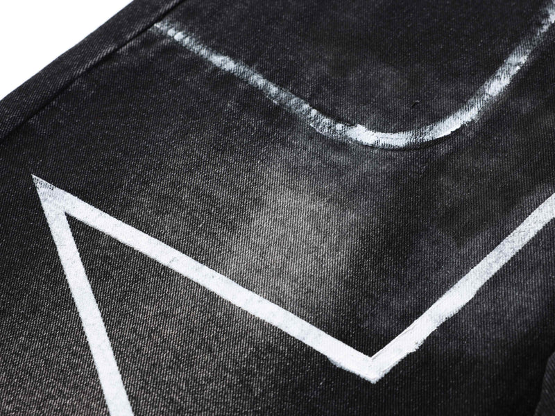 Close-up of black denim pocket area with white star graphic and faded wash