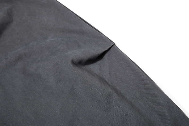 Close-up of dark gray pant leg with soft folds and wide hem
