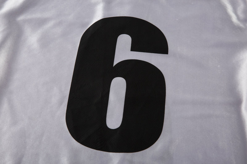Close-up of white jersey back with large black number 6