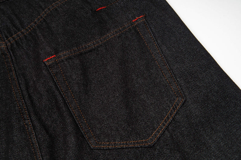 Close-up of dark wash denim back pocket with red stitching detail