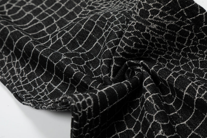 Close-up of black pants fabric folds and crocodile-style texture