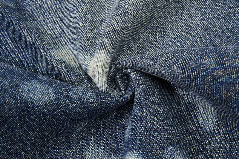 Close-up of crumpled blue denim fabric with faded wash texture