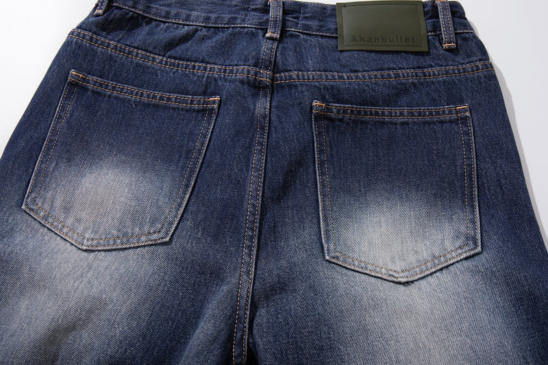 Close-up of two back pockets on faded blue denim jeans