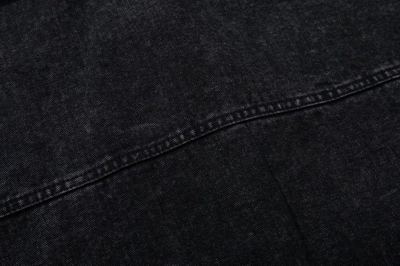 Close-up of black washed denim fabric with stitched seam detail