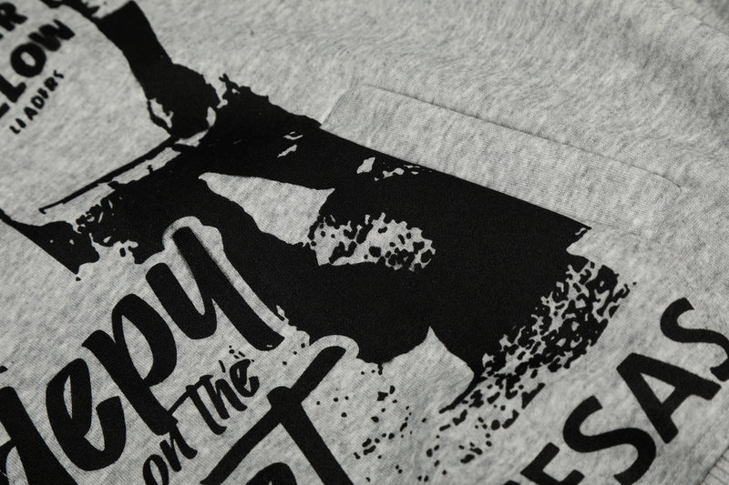 Close-up of light gray hoodie front pocket area with black collage print
