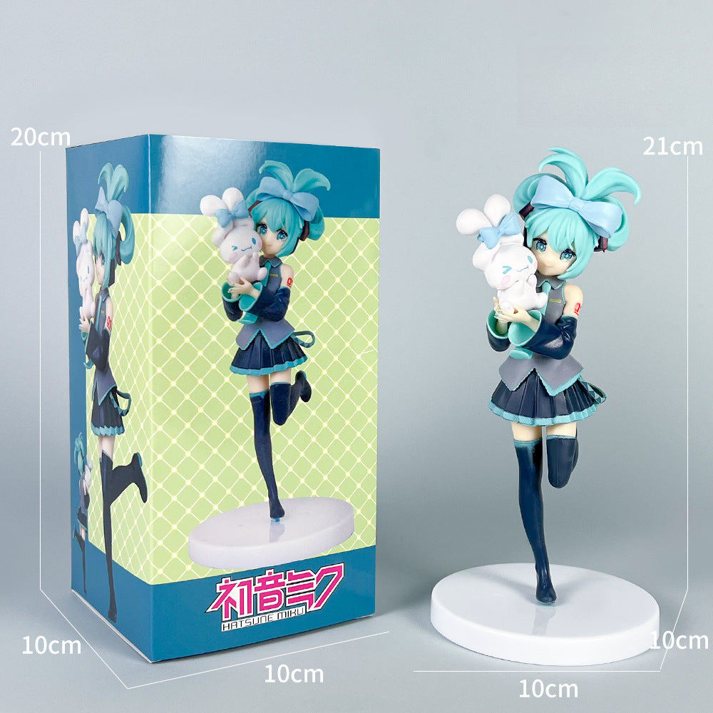 The Hatsune Miku Holding Cinnamoroll 21cm PVC Figure, featuring Miku with teal hair cradling a white rabbit, stands gracefully on a 10cm base. It&