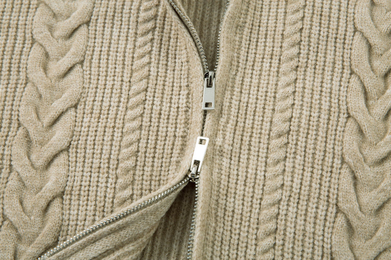 Beige cable knit sweater jacket partially unzipped, close-up of front zipper