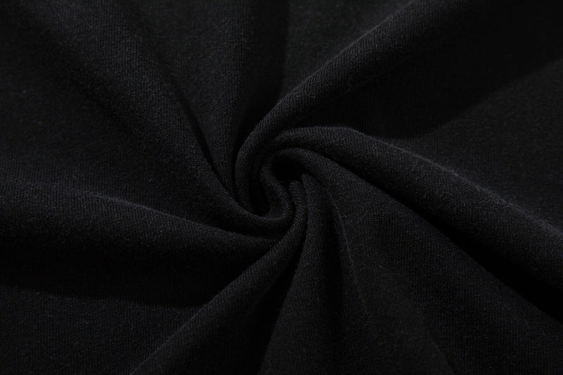Close-up of black washed cotton fabric with a soft, textured swirl and faded streetwear graphic tee finish
