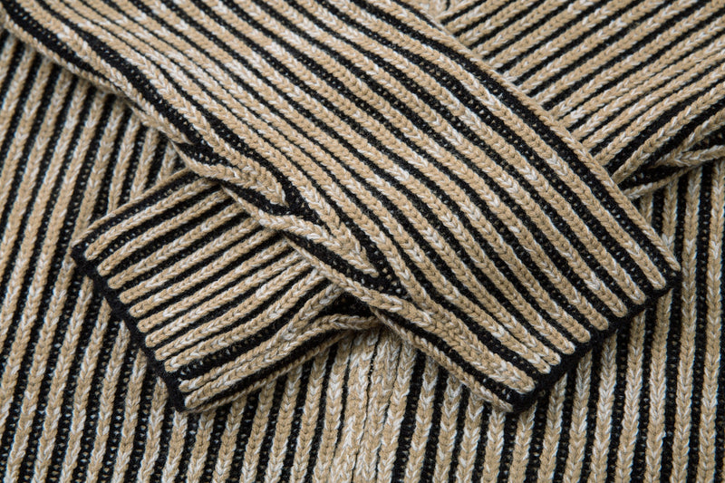 Close-up of the ribbed striped sleeve cuff on the knit jacket