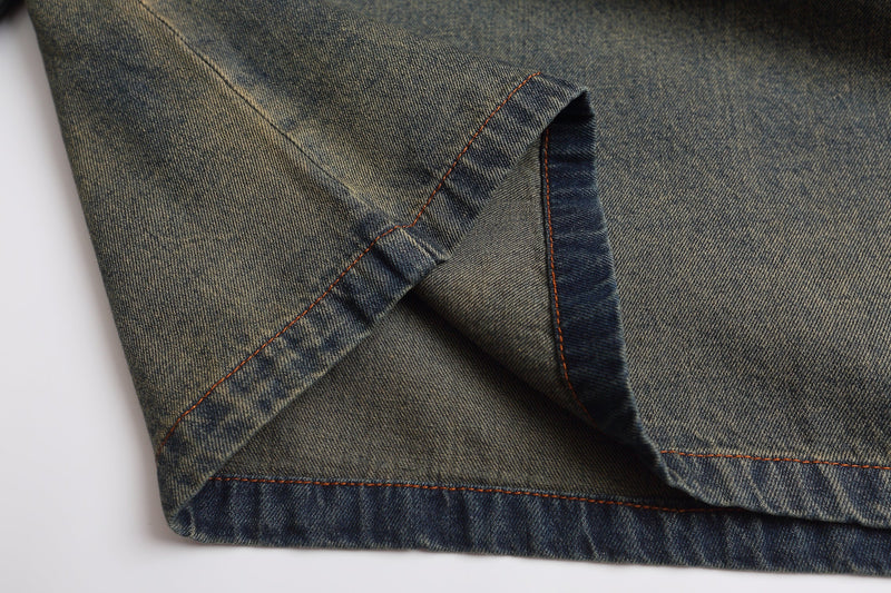 Close-up of denim sweatshirt hem with visible seam stitching and faded wash