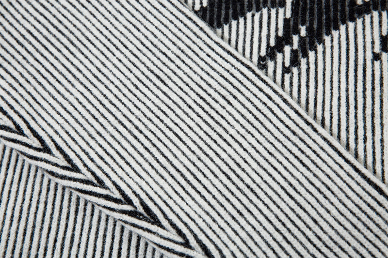 Close-up of white ribbed knit sweater sleeve and black stripe pattern