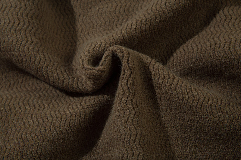 Close-up of brown textured knit fabric showing soft wavy stitch pattern