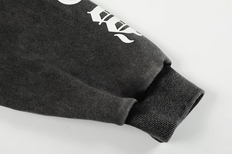 Close-up of black hoodie sleeve with white print and ribbed cuff