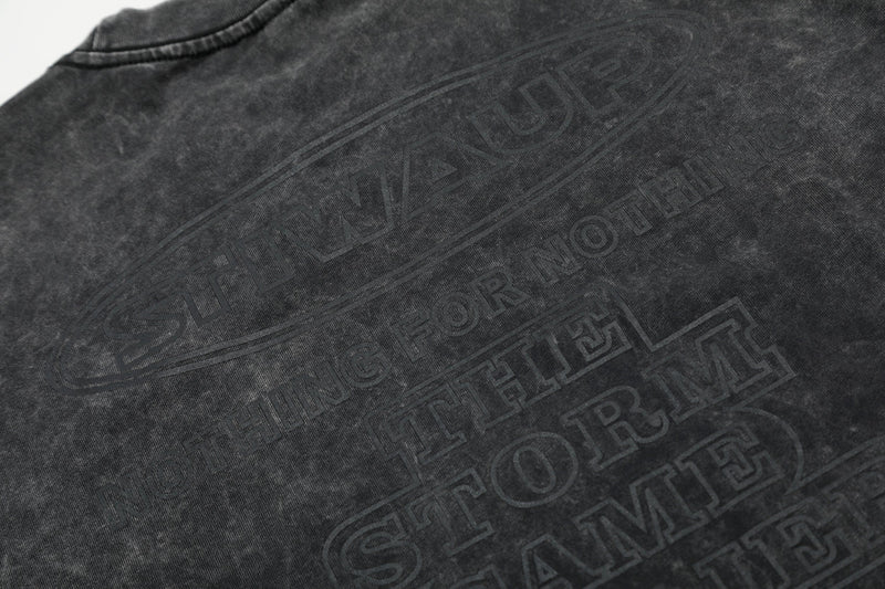 Washed black oversized cotton T-shirt with embossed flame graphic and faded streetwear lettering