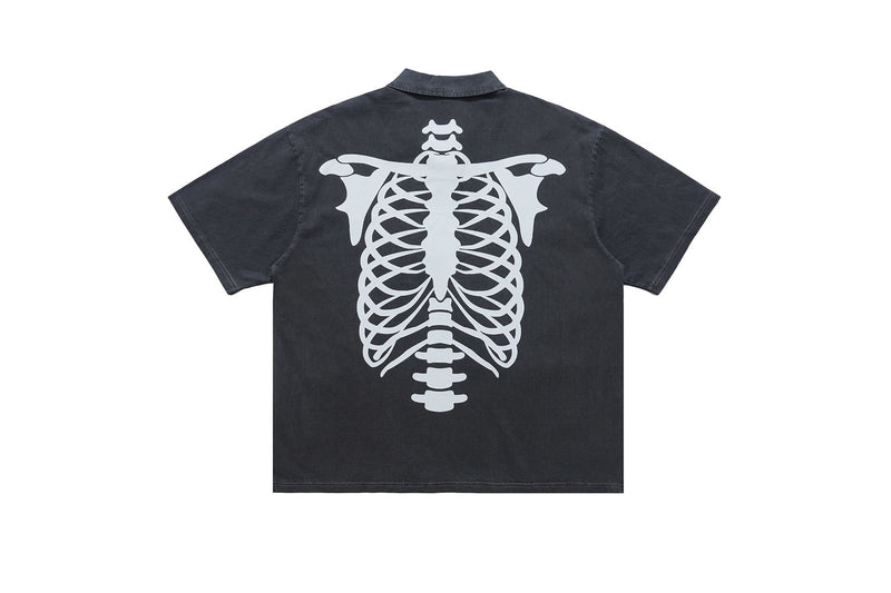 Black washed polo shirt with a large white skeleton spine graphic on the back and short sleeves