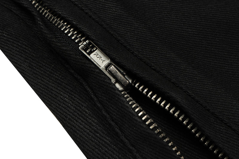 Close-up of black zipper pull and metal teeth on denim