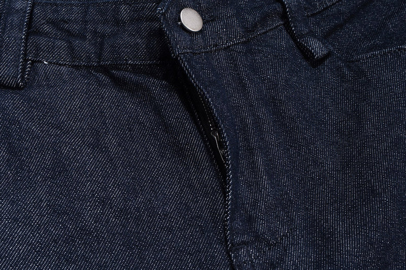 Close-up of front fly and silver button on dark indigo denim shorts