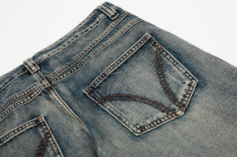Close-up of the back pockets and waistband on retro faded blue denim jeans