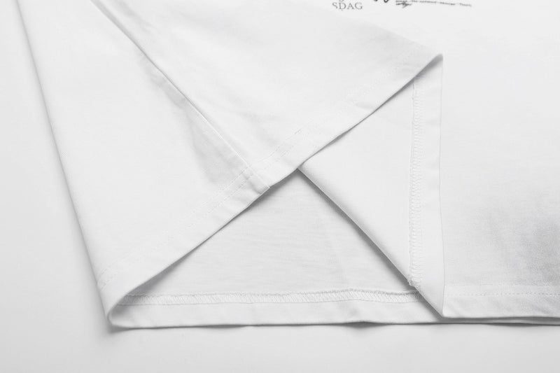 Close-up of folded white graphic T-shirt with visible hem stitching and soft cotton texture