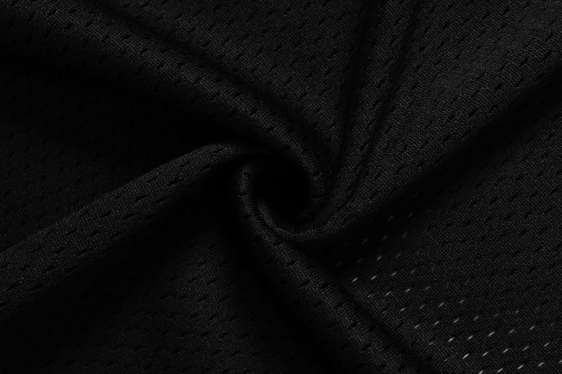 Black mesh fabric close-up with folds and fine perforated texture