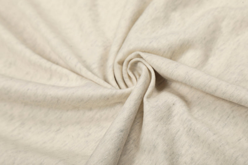 Close-up of soft cream fabric gathered in a spiral fold