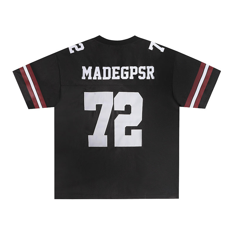 Black varsity football jersey with white 72 and MADEGPSR lettering, striped sleeves, and classic streetwear style