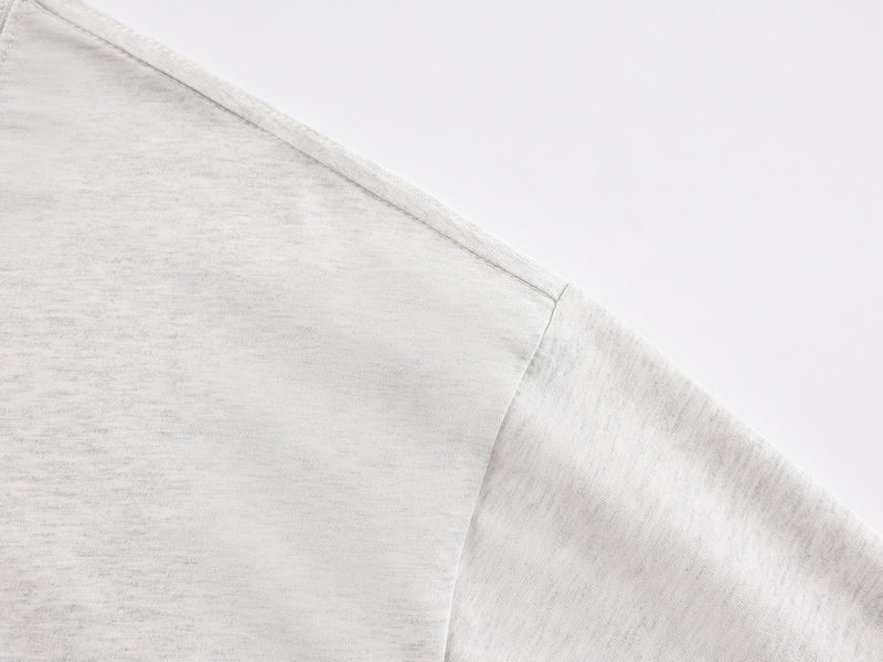 Close-up of heather gray tee shoulder seam and sleeve in soft knit fabric