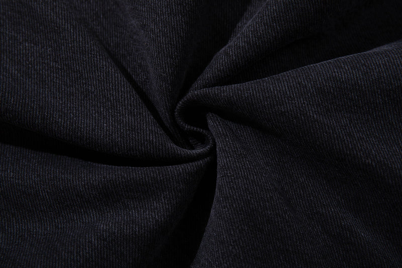 Close-up of dark wash denim fabric texture with gathered folds