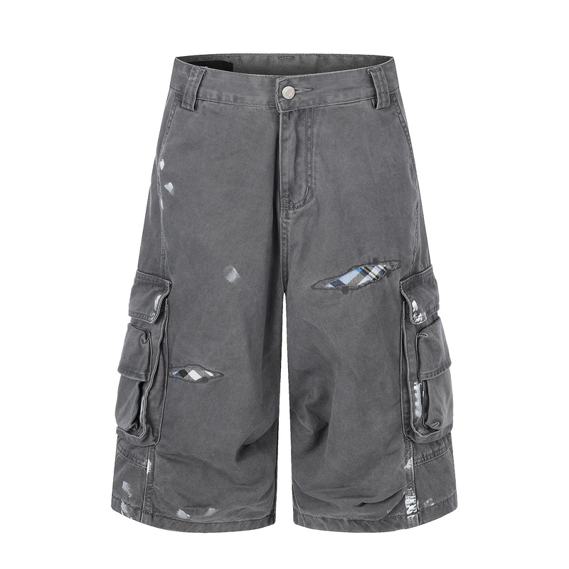 Gray distressed cargo shorts front view with flap side pockets and plaid tear details