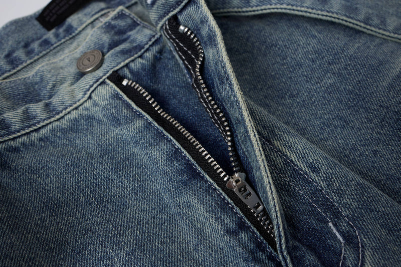 Close-up of light wash denim shorts zipper fly and waistband button
